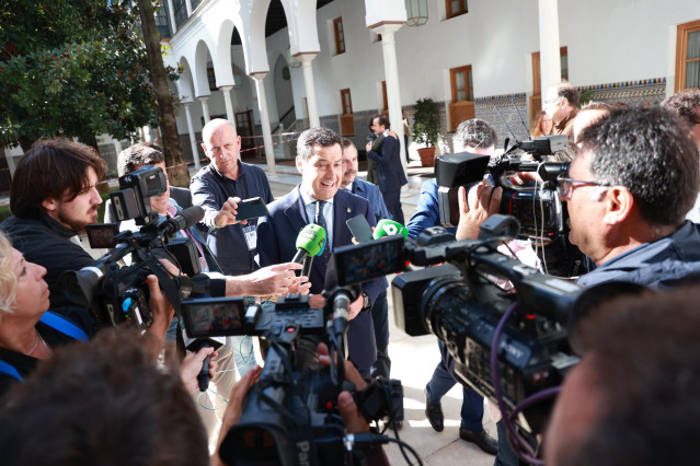 El presidente de la Junta, Juanma Moreno (c), atiende a los medios, a su llegada a la Sesión de Control al Gobierno de la Junta de Andalucía.