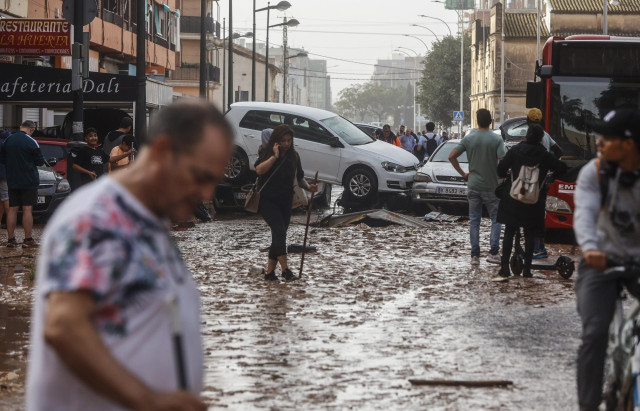 Varias personas realizan labores de limpieza tras el paso de la DANA por el barrio de La Torre