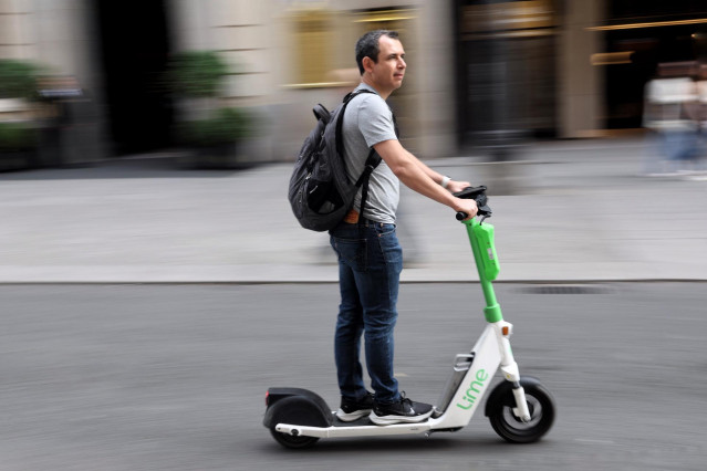 Archivo - Un hombre montado en un patinete eléctrico.