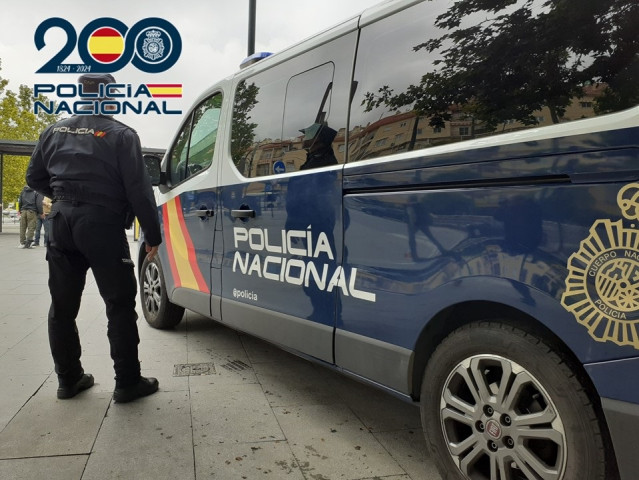 Agente de la Policía junto a un coche de este cuerpo policial