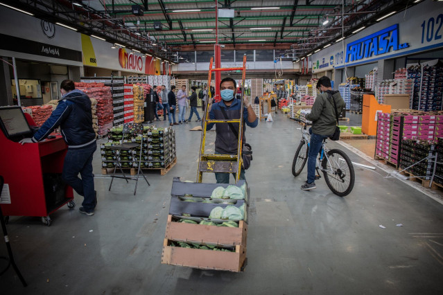 Archivo - Un trabajador de Mercabarna transporta productos en cajas dentro del recinto. En Barcelona, Cataluña, (España), a 17 de abril de 2020.