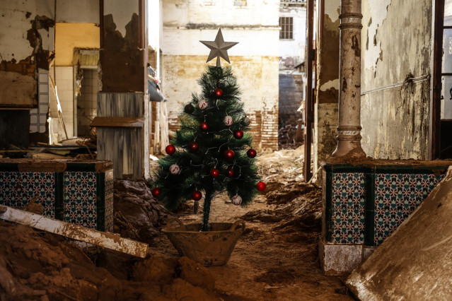 Un árbol de Navidad en una zona cubierta de barro por la Dana en Valencia