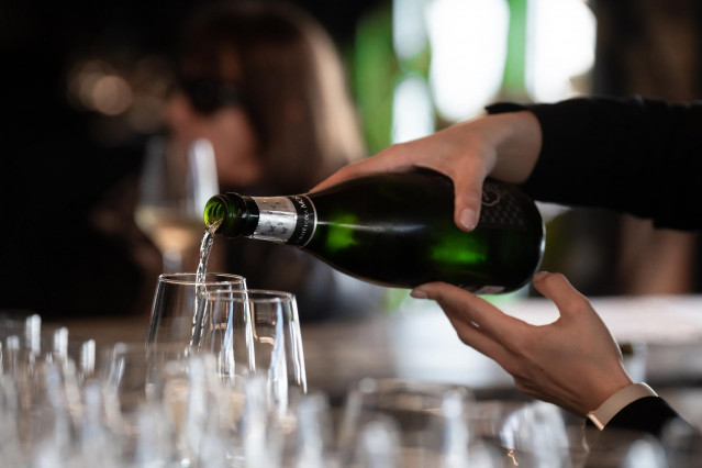 Archivo - Una mujer sirve una copa de cava