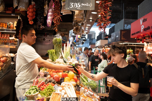 Archivo - Una persona comprando en un mercado