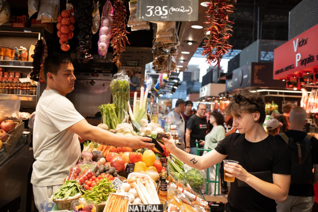 Archivo - Una persona comprando en un mercado