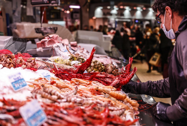 Archivo - Un vendedor en un puesto de marisco, en el Mercado Central de Valencia