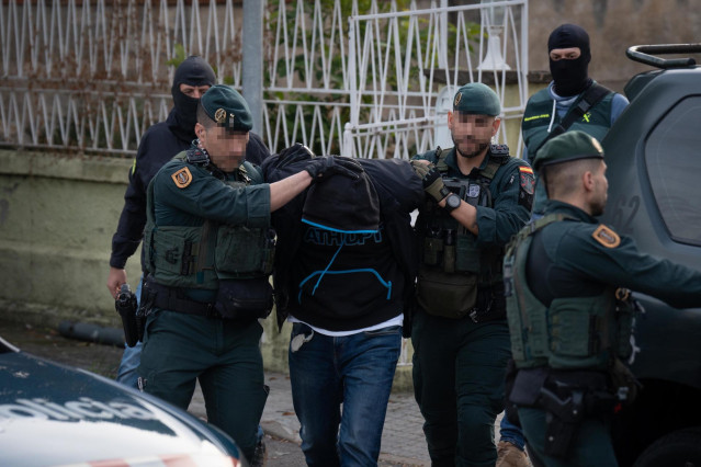 Archivo - Varios agentes de la Guardia Civil llevan a un detenido tras una operación policial antiyihadista en Barcelona