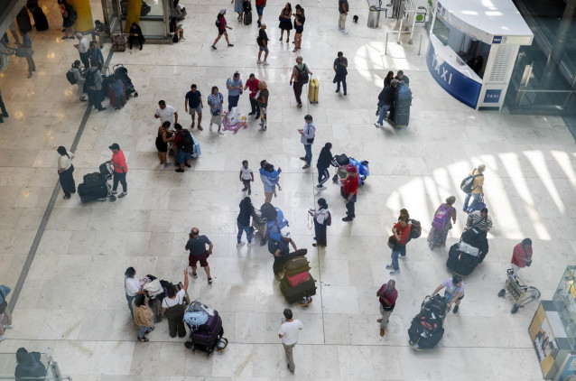 Archivo - Varias personas con maletas en la terminal T4 del aeropuerto Adolfo Suárez Madrid-Barajas, en Madrid (España).