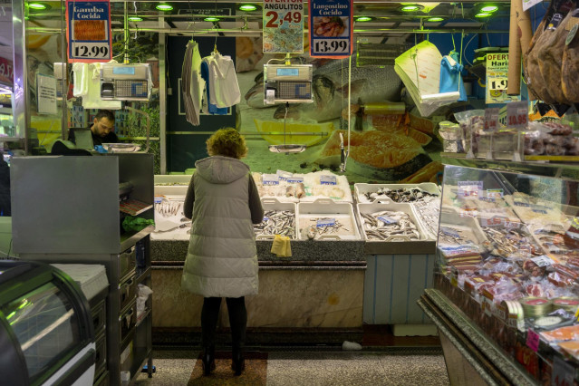 Archivo - Una mujer compra en una pescadería en un mercado en Madrid (España).