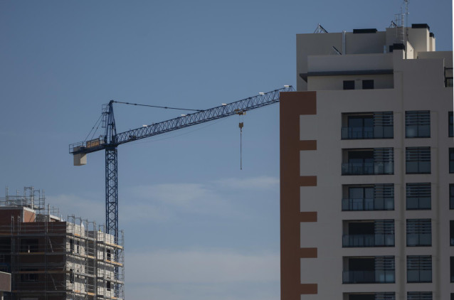 Archivo - Una grúa en una zona de construcción de edificios