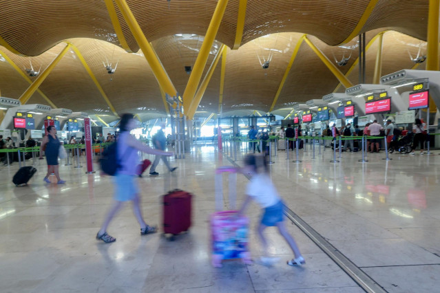 Archivo - Una mujer y una niña caminan con sus maletas, con motivo de la operación salida del puente de agosto, en la T4, en el aeropuerto Adolfo Suárez Madrid-Barajas, a 14 de agosto de 2024, en Madrid (España).