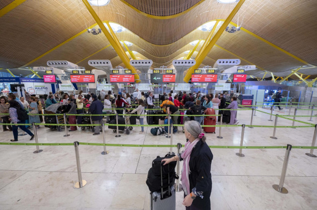 Archivo - Un grupo de personas esperan a facturar sus maletas en la terminal T4 del aeropuerto de Adolfo Suárez-Madrid Barajas, a 28 de abril de 2023, en Madrid (España).