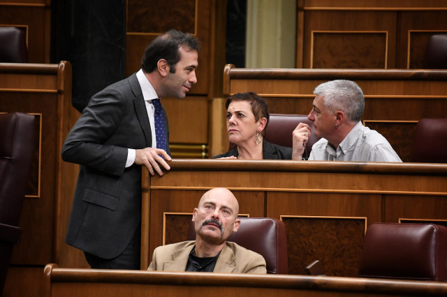 Archivo - (I-D) El ministro de Economía y Comercio, Carlos Cuerpo; conversa con los diputados de EH Bildu, Mertxe Aizpurua y Oskar Matute, durante una sesión de control al Gobierno en el Congreso de los Diputados, a 11 de diciembre de 2024, en Madrid (Esp