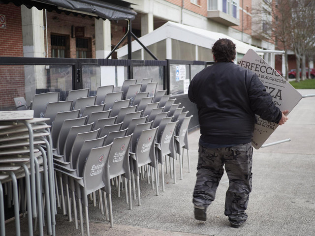 Archivo - Un camarero colocando las sillas de una terraza en una céntrica calle de Pamplona