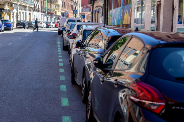 Archivo - Varios coches aparcados en zona verde en Madrid (España).