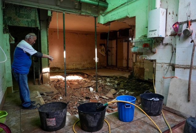 Una persona observa un agujero en el interior de una casa de Paiporta, a 10 de enero de 2025, en Paiporta, Valencia, Comunidad Valenciana (España).