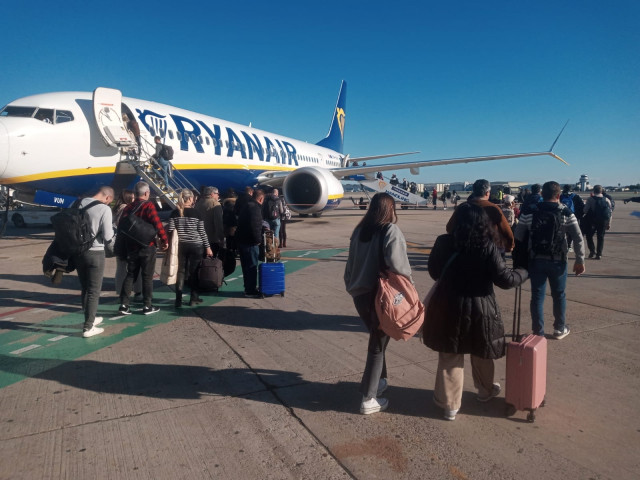 Pasajeros de un vuelo de Ryanair suben a bordo de un avión estacionado en el aeropuerto de Sevilla.
