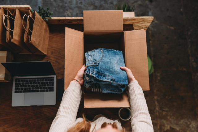 Archivo - A millennial woman is preparing the shipment of some clothes in her new online shop. She's the owner of an online thrift store. New small business concept.