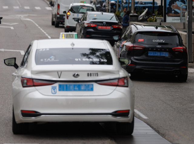 Archivo - Un taxi circulando junto a un VTC, a 8 de junio de 2023, en Madrid (España).