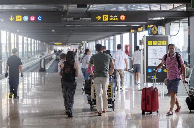 Archivo - Varias personas con maletas en la terminal T4 del aeropuerto Adolfo Suárez Madrid-Barajas.