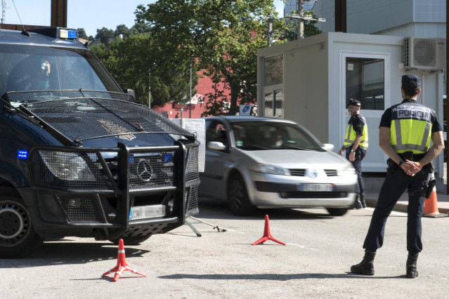 Archivo - Dos agentes de la Policía Nacional controlan la frontera de La Junquera, en Girona