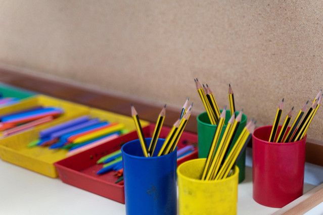 Archivo - Varios botes llenos de lápices en una clase (archivo)