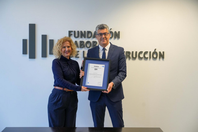 La directora de personas y organización de Aenor, Susana Pedrero, otorga el premio al director general de la Fundación Laboral de la Construcción, Julio Gil Iglesias.