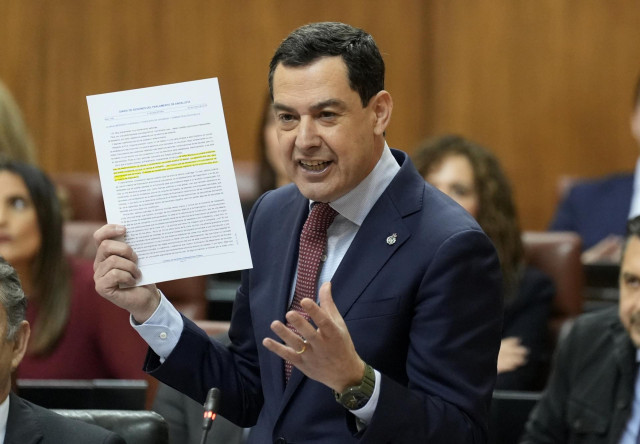 El presidente de la Junta de Andalucía, Juanma Moreno, este jueves en el Pleno del Parlamento andaluz blandiendo en su respuesta al PSOE un Diario de Sesiones subrayado.