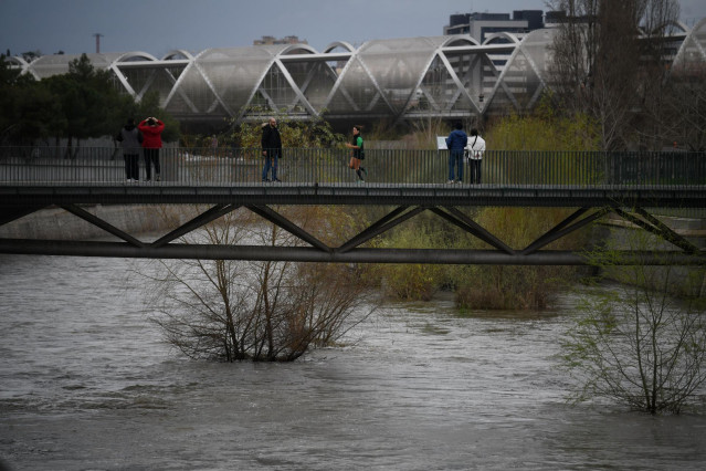 Varias personas, en el parque de Madrid Río, a 20 de marzo de 2025, en Madrid (España). El río Manzanares y las presas madrileñas de El Pardo se encuentran al borde de su capacidad por el paso de la borrasca Martinho y tras varias jornadas de intensas llu