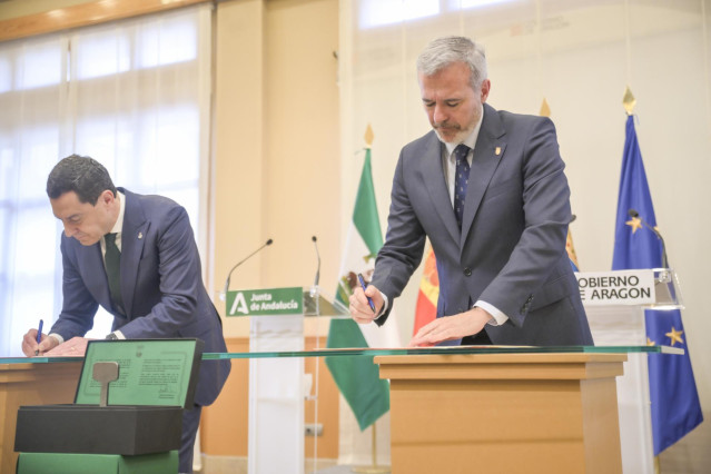 El presidente de la Junta de Andalucía, Juan Manuel Moreno (i) y el presidente del Gobierno de Aragón, Jorge Azcón (d), firman un acuerdo.