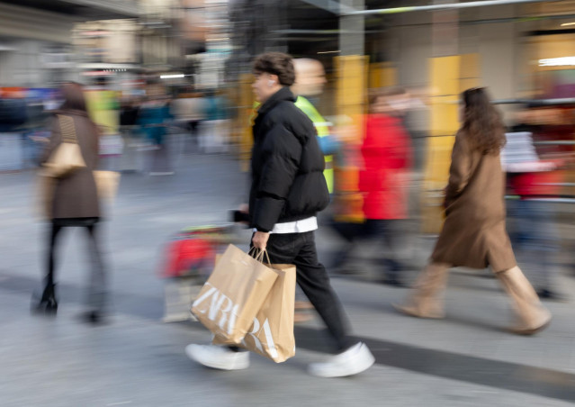 Archivo - Varias personas con bolsas durante las rebajas del pasado mes de enero