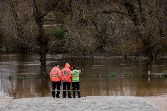 Tres agentes del SAMUR observan el parking de Somontes inundado, a 21 de marzo de 2025, en Madrid (España).