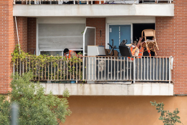 Archivo - Trabajadores sacan al balcón de un domicilio las pertenencias de las 62 familias que han desalojado de cuatro portales, a 2 de junio de 2023, en Alcobendas, Madrid (España).