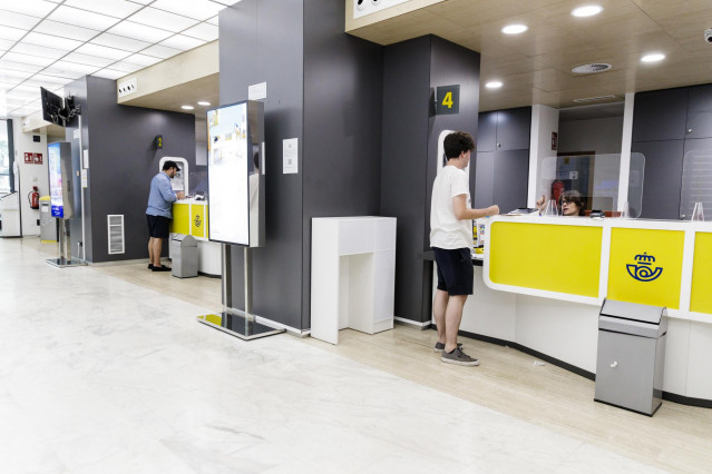 Archivo - Un joven es atendido en la oficina de Correos de la calle Conde de Peñalver, Madrid