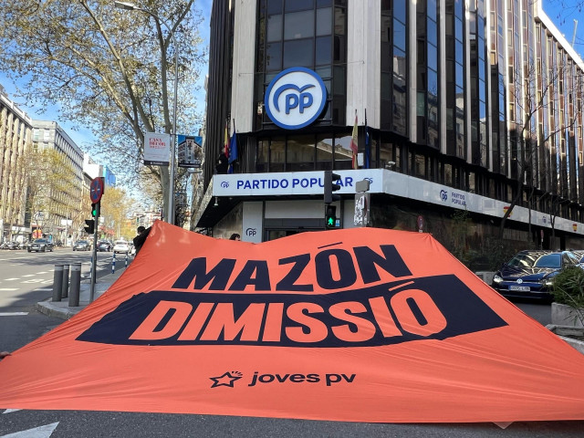 Las juventudes de Compromís despliegan en 'Génova' una gran pancarta para pedir la dimisión de Mazón