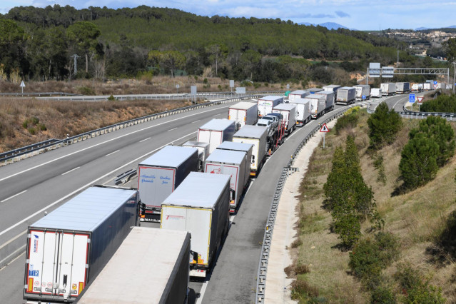 Archivo - Fila de camiones de mercancías en una carretera europea.