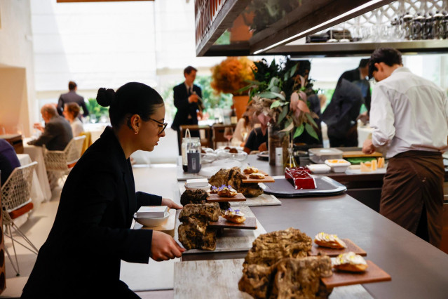 Archivo - Una camarera con uno de los platos del menú degustación del restaurante 'Disfrutar' de Barcelona, a 6 de junio de 2024, en Barcelona, Catalunya (España).