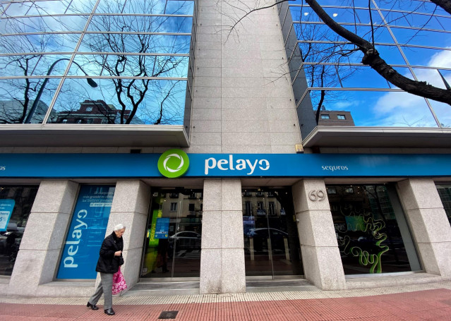 Archivo - Una persona pasa por delante de una oficina de la compañía aseguradora Pelayo, en Madrid a 17 de diciembre de 2019.