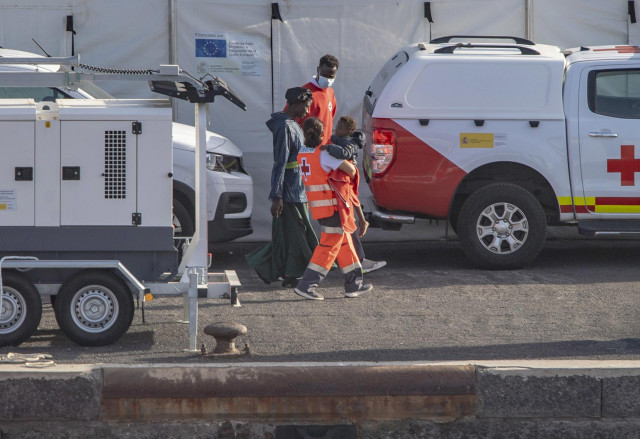 Archivo - Agentes de los Servicios de Emergencias atienden a una mujer y un menor a su llegada al Puerto de La Restinga