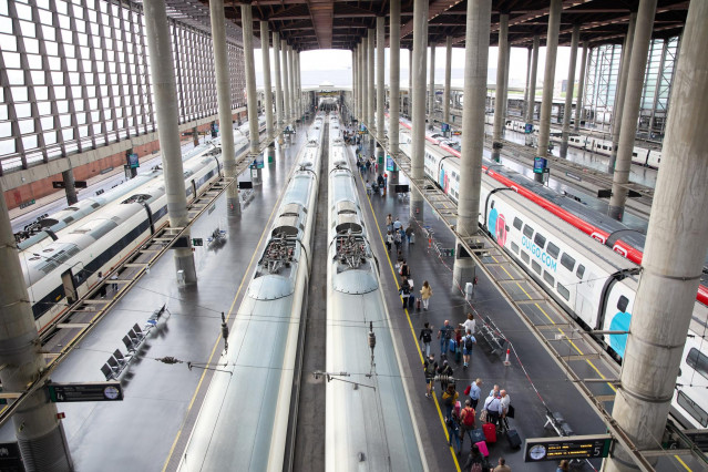 Archivo - Viajeros con maletas en uno de los andenes de la estación Almudena Grandes-Atocha
