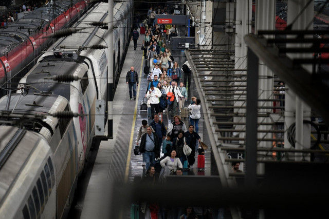 Decenas de personas con maletas, en la estación Puerta de Atocha-Almudena Grandes