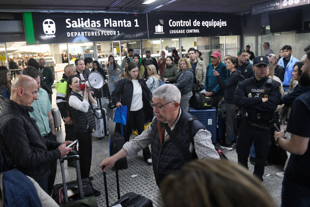 Una trabajadora con un megáfono en la estación de Atocha-Almudena Grandes, tras los retrasos en los trenes AVE, a 5 de mayo de 2025, en Madrid (España).