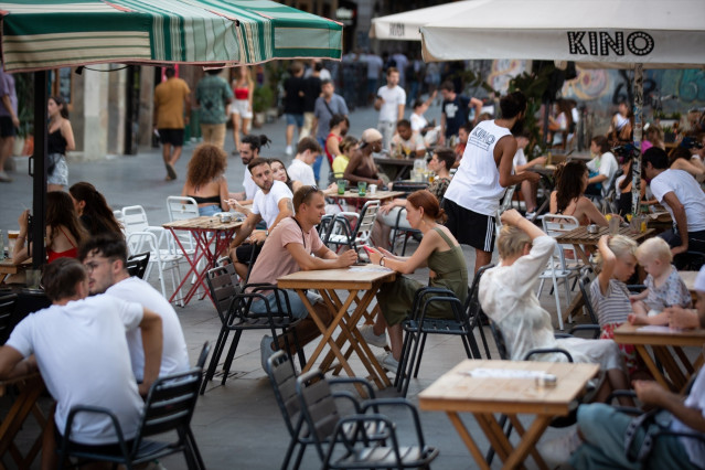 Archivo - Varias personas sentadas en terrazas en la plaza dels Àngels del Raval, en Barcelona.