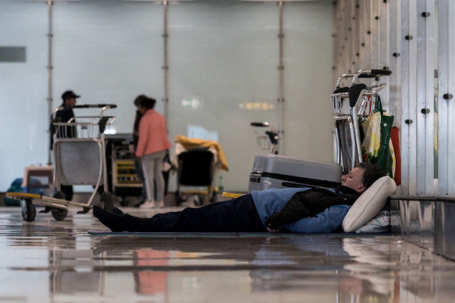 Un hombre tumbado en el suelo en la T4 del Aeropuerto Adolfo Suárez-Madrid Barajas, a 12 de mayo de 2025, en Madrid (España). Varios centenares de personas sin hogar viven y pernoctan en las instalaciones del Aeropuerto Adolfo Suárez-Madrid Barajas. Las d