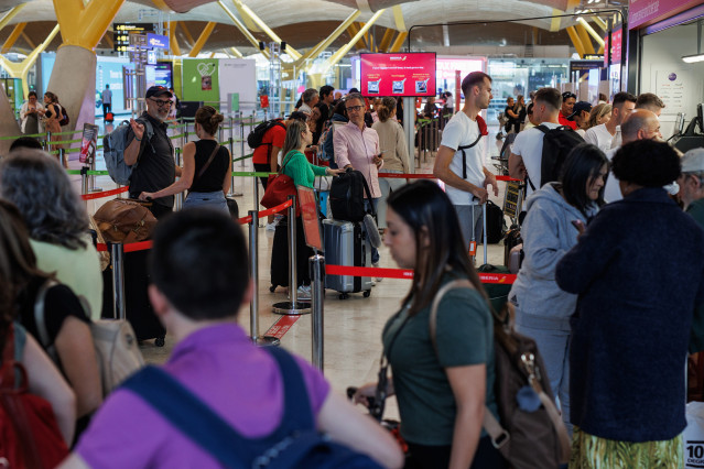 Archivo - Varias personas en la terminal T4 del aeropuerto Adolfo Suárez-Madrid Barajas