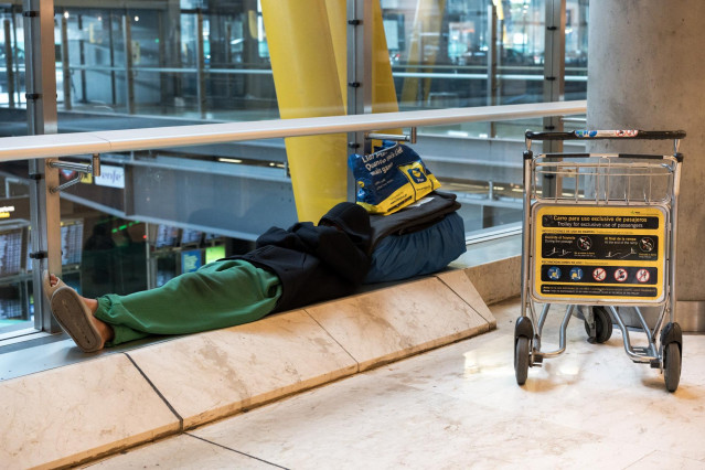 Una persona duerme en la T4 del Aeropuerto Adolfo Suárez-Madrid Barajas, a 12 de mayo de 2025, en Madrid (España).