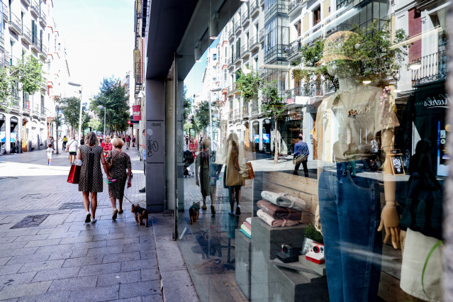 Archivo - Varias personas pasan por delante de un escaparate de una tienda de ropa