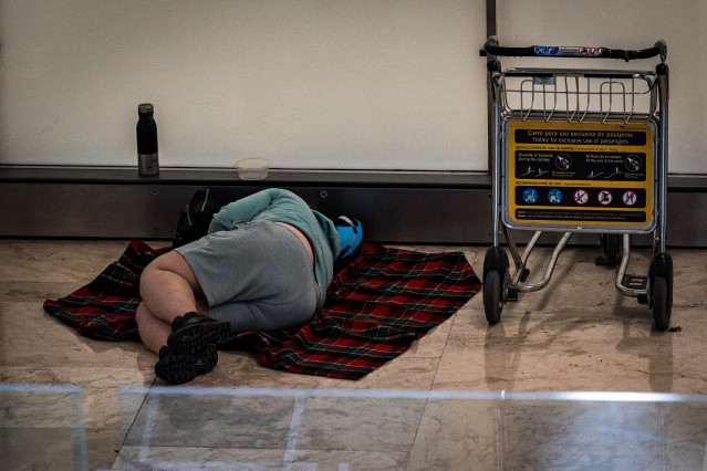 Una persona duerme en la T4 del Aeropuerto Adolfo Suárez-Madrid Barajas, a 12 de mayo de 2025, en Madrid (España). Varios centenares de personas sin hogar viven y pernoctan en las instalaciones del Aeropuerto Adolfo Suárez-Madrid Barajas. Las denuncias de