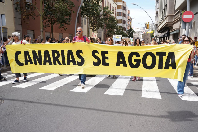 Archivo - Varias personas protestan con una pancarta durante una manifestación contra el modelo turístico, a 20 de abril de 2024, en Santa Cruz de Tenerife, Tenerife, Canarias (España).