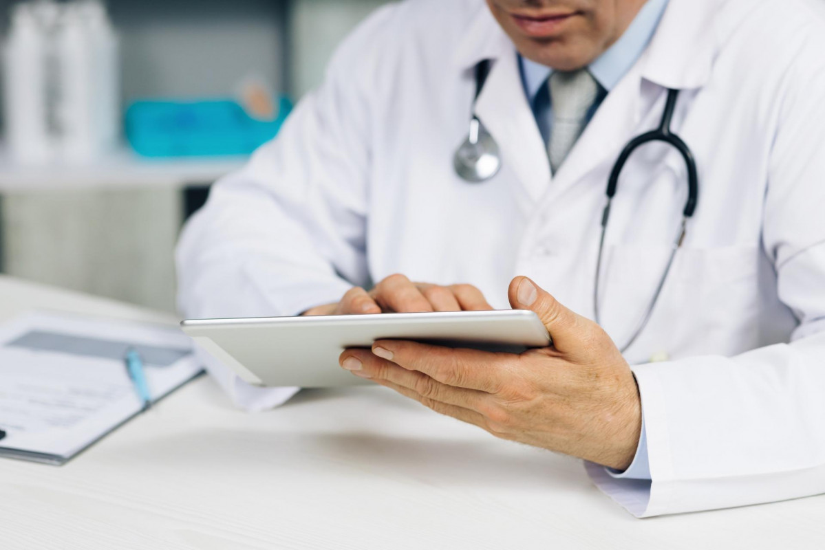 Primer plano de manos de un mu00e9dico utilizando una tablet   Close up of a doctor's hands using a tablet